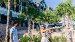couple playing cornhole on resort lawn